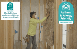 Certified Insulation.Installer places fiberglass insulation in wall cavity while wearing a mask, next to the Asthma & Allergy Friendly® Certification mark