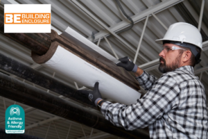 Worker installing Asthma & Allergy Friendly® Certified Knauf Performance+® pipe insulation in a commercial building