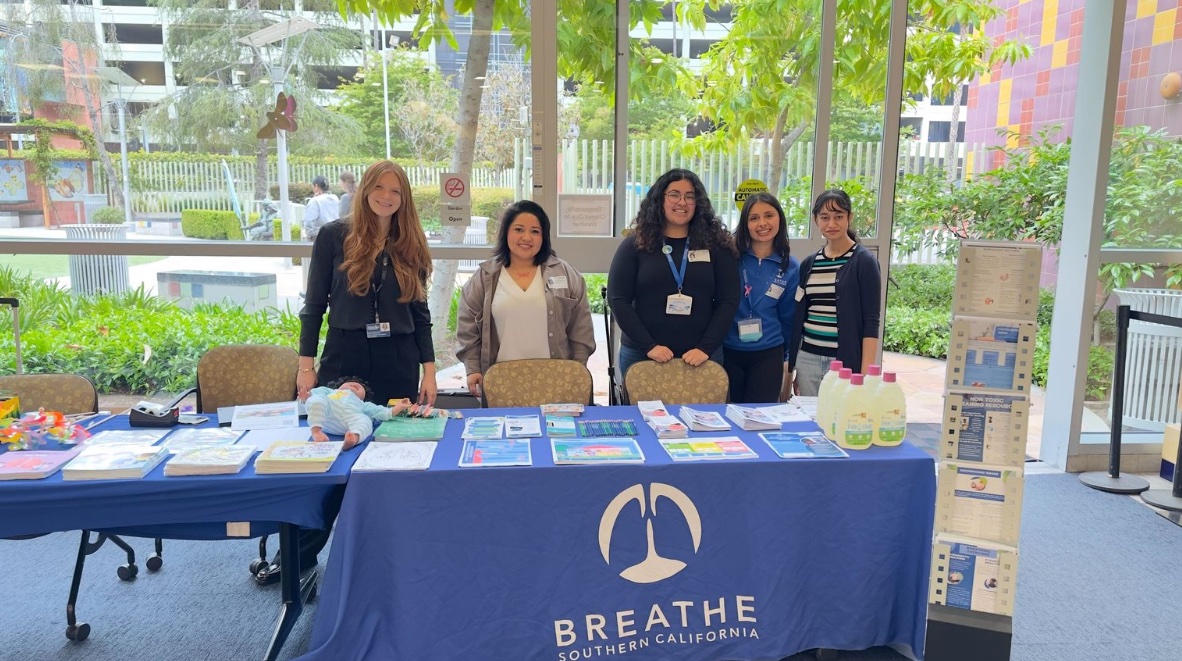 Breathe Southern California team at community health event with educational materials on asthma and allergies.