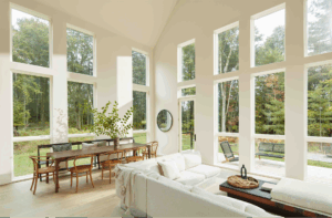 Living and dining room with large windows and walls painted in Benjamin Moore Eco Spec® Dove Wing, a CERTIFIED asthma & allergy friendly® low VOC paint.