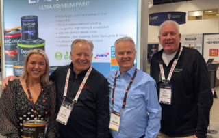 Leah McInerney with John Vanderpool, Dave Morrissey and Rich White at the True Value EasyCare paint booth during the Do it Best & True Value Spring Market